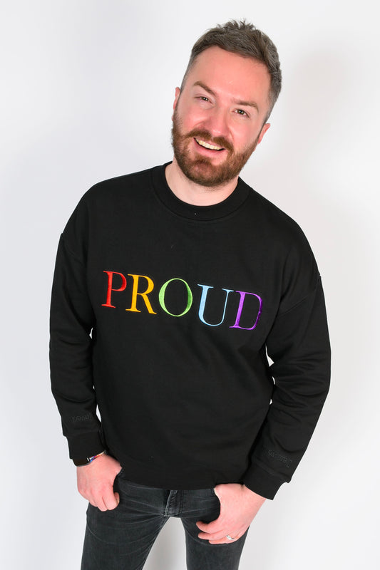  a beautiful black high quality oversized Jumper with a bright rainbow letters spelling out 'PROUD.' The sleeves have reassuring messages which read 'I am Loved' and 'I am Worthy'