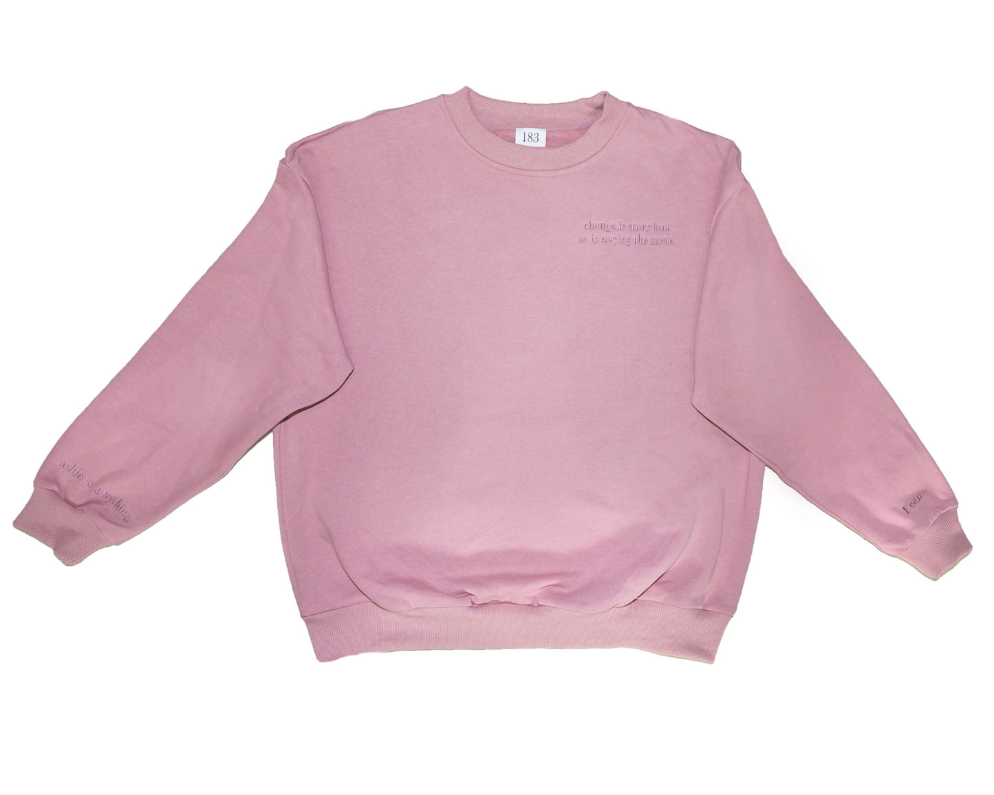 A dusty pink, cotton oversized embroidered jumper with the message "Change is scary but so is staying the same" in small letters across the chest. This mental health clothing piece also features reassuring messages on the cuffs that read "I can" and "achieve anything."