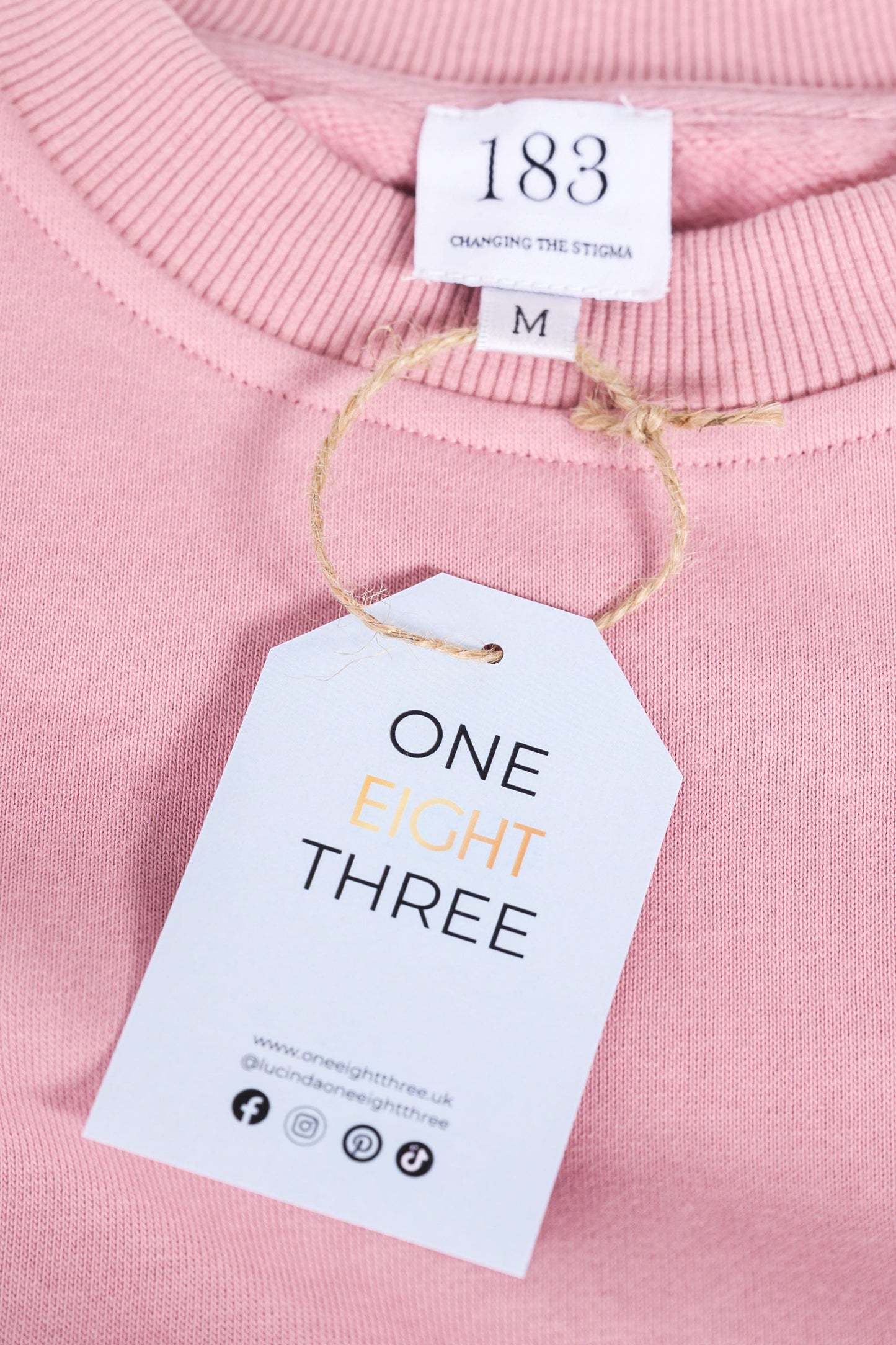 A dusty pink, cotton oversized embroidered jumper with the message "Change is scary but so is staying the same" in small letters across the chest. This mental health clothing piece also features reassuring messages on the cuffs that read "I can" and "achieve anything."