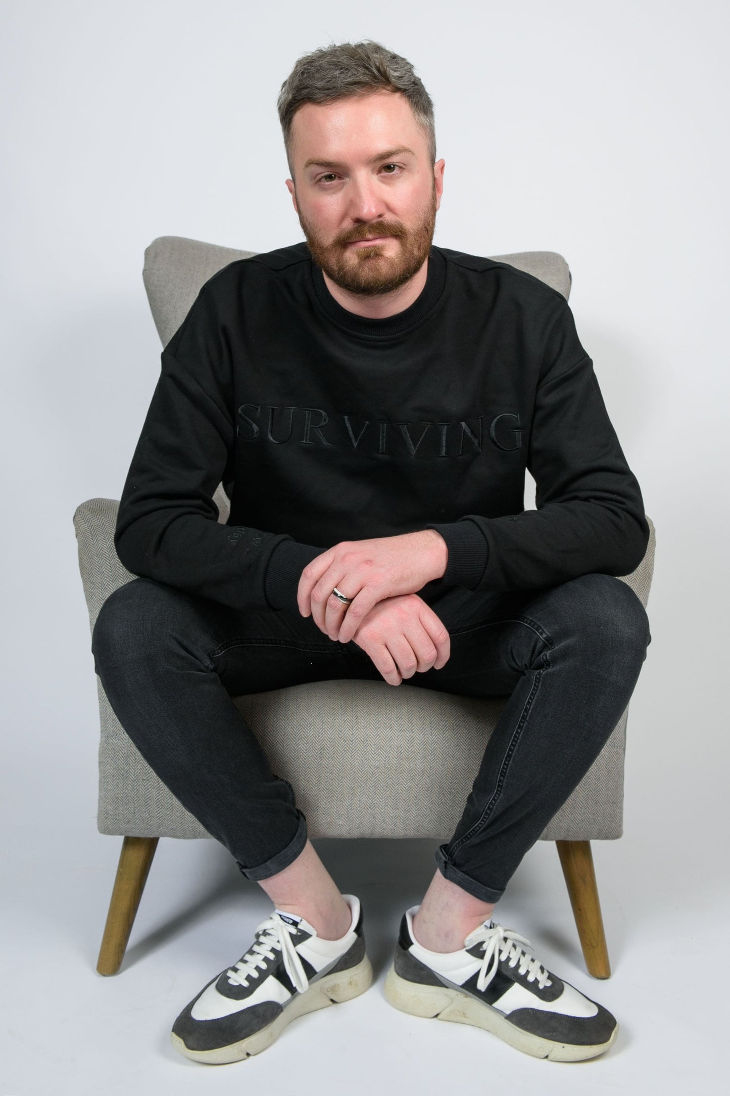 Our Surviving black embroidered jumper from our mental health clothing collection, featuring the uplifting message "Surviving" across the chest. Additional encouraging phrases include "Tomorrow's a new day" and "I can do this," elegantly stitched to inspire resilience.