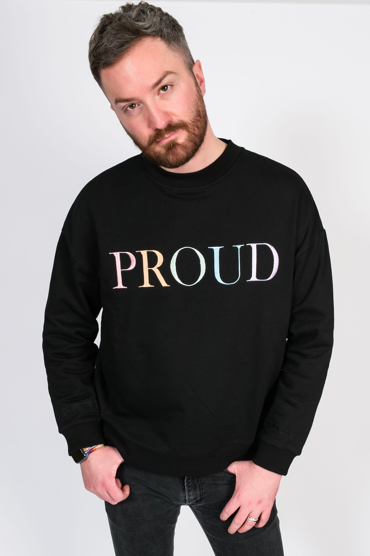 A beautiful black high quality oversized Jumper with a pastel rainbow letters spelling out 'PROUD.' The sleeves have reassuring messages which read 'I am Loved' and 'I am Worthy'