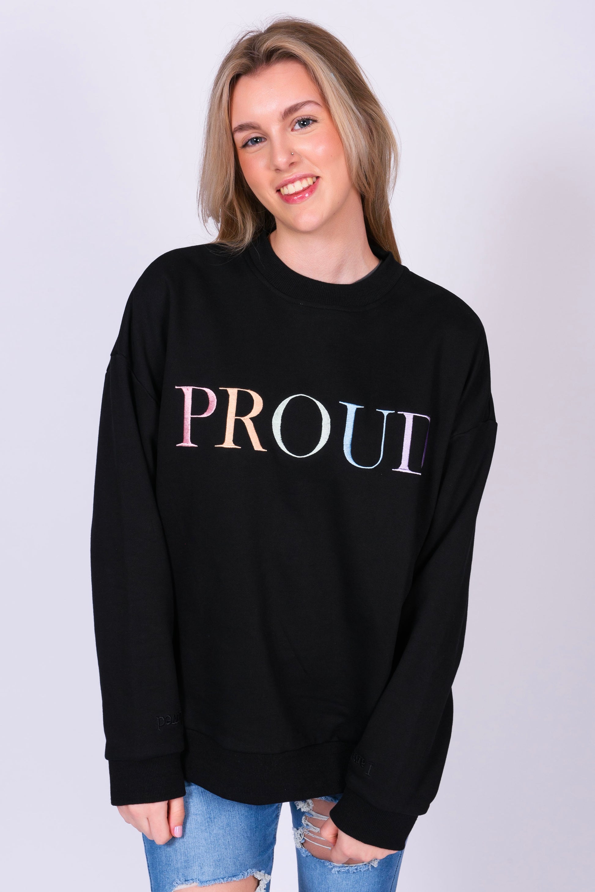 A beautiful black high quality oversized Jumper with a pastel rainbow letters spelling out 'PROUD.' The sleeves have reassuring messages which read 'I am Loved' and 'I am Worthy'